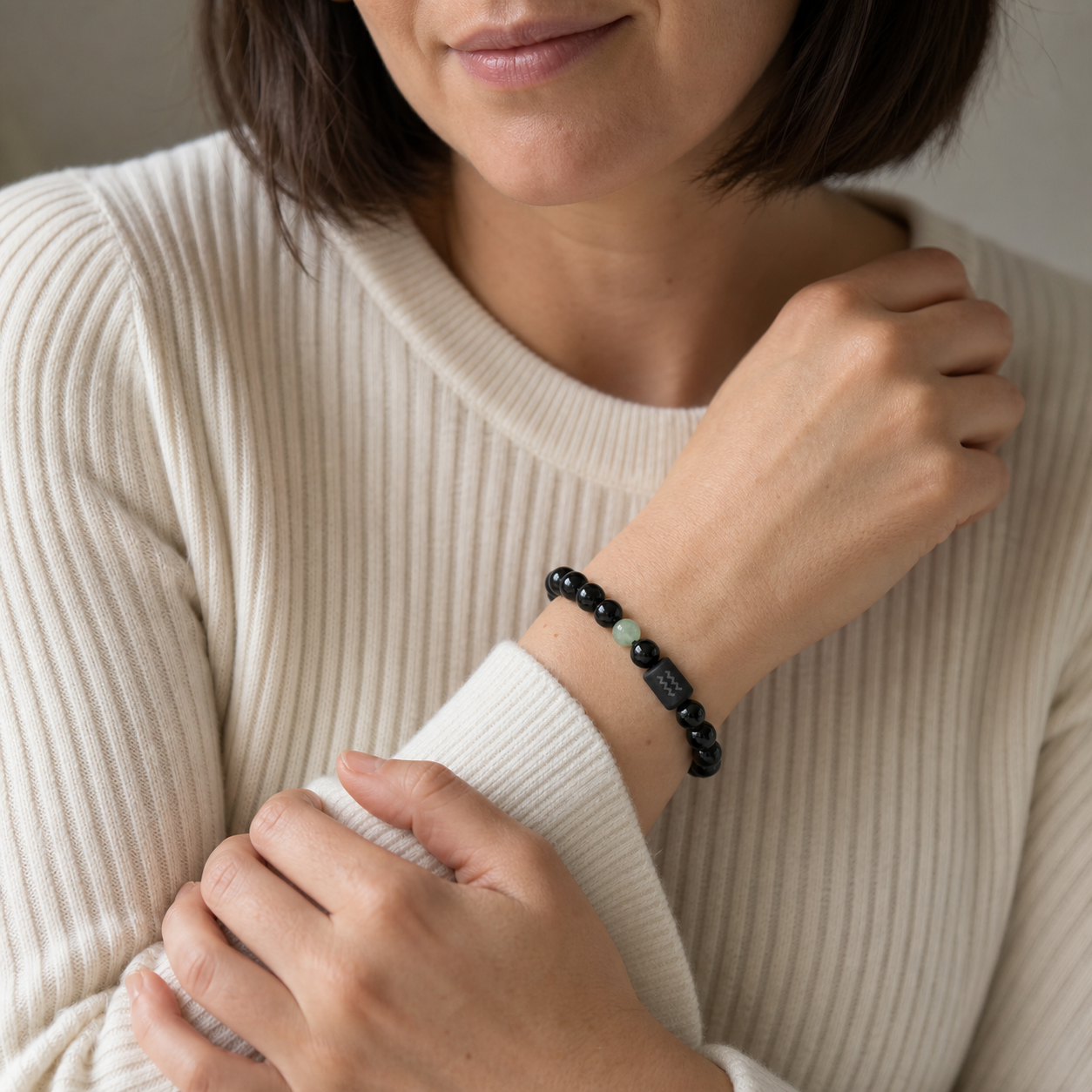 Woman wearing an Aquarius Zodiac Bracelet with obsidian and Tiger’s Eye beads