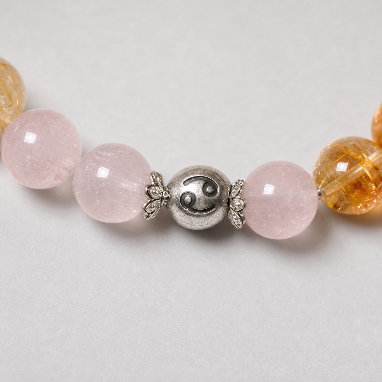 Close-up of Cancer Crystal Bracelet with amethyst, rose quartz and golden crystal details