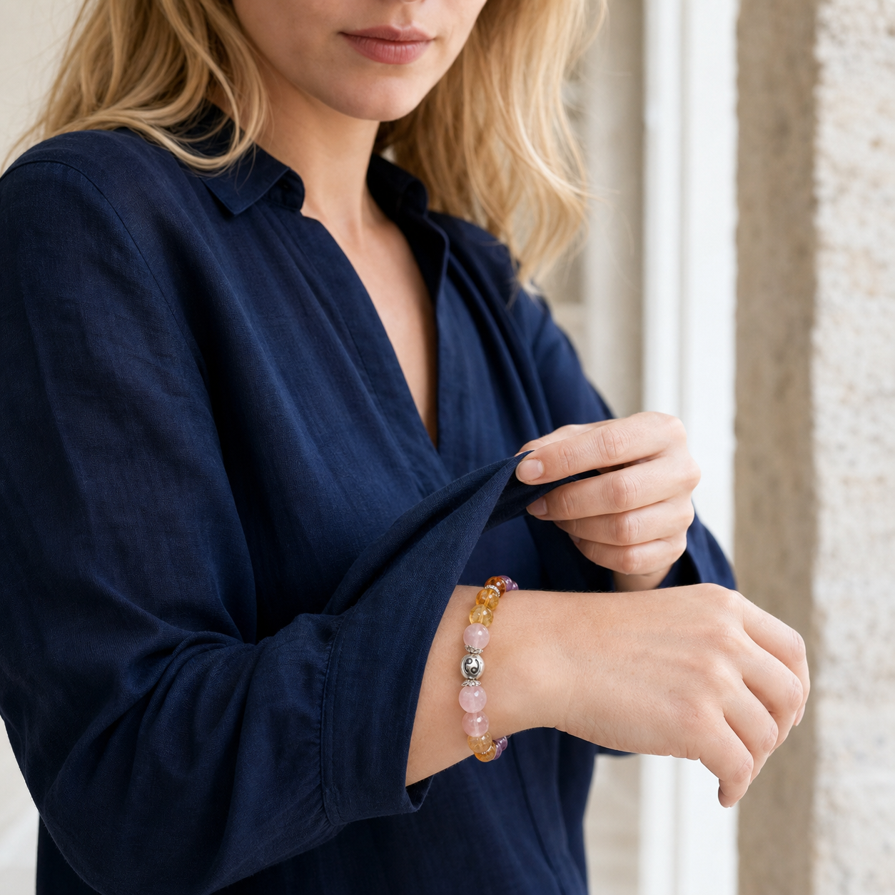 Woman wearing a Cancer Crystal Bracelet with amethyst, rose quartz and golden crystal beads