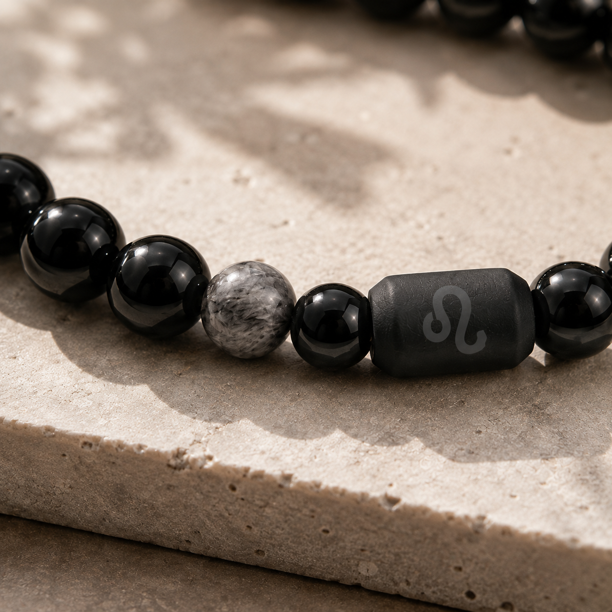 Close-up of the Leo zodiac symbol with obsidian and Tiger’s Eye beads