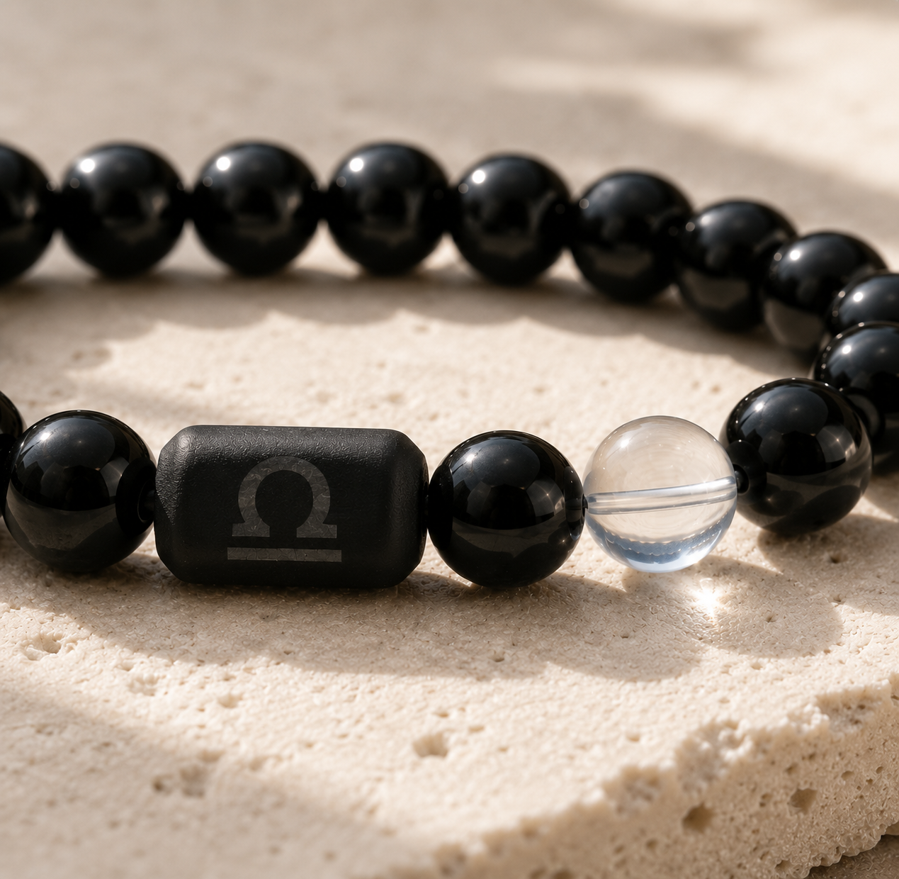 Close-up of the Libra zodiac symbol with obsidian and Tiger’s Eye beads
