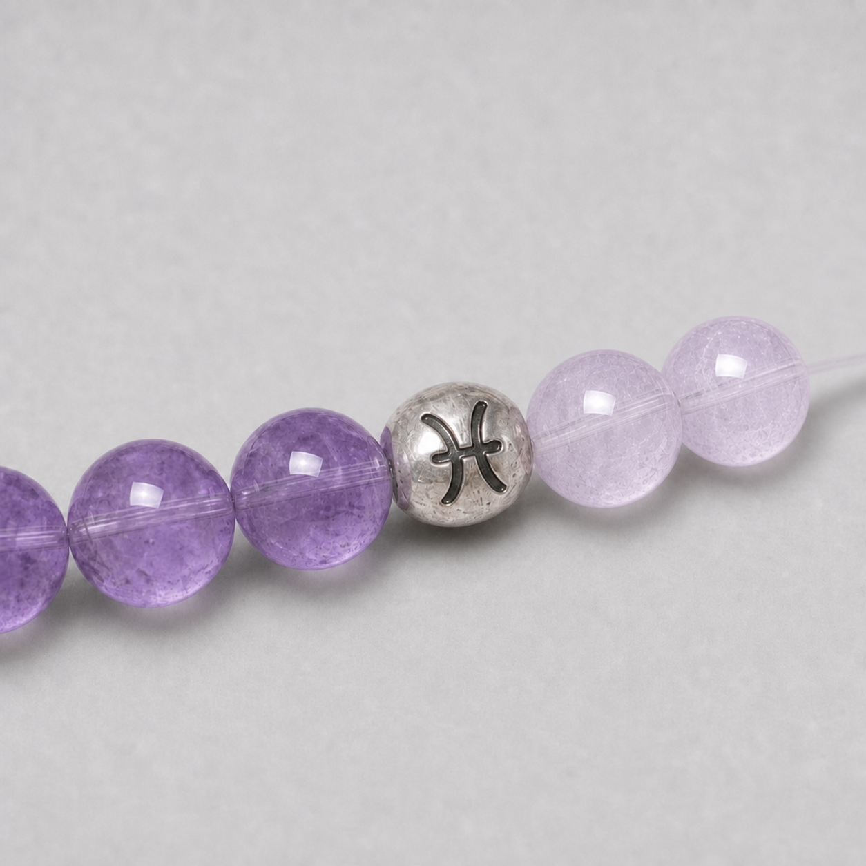 Close-up of Pisces Crystal Bracelet with Aquamarine, Amethyst, Rose Quartz and zodiac details