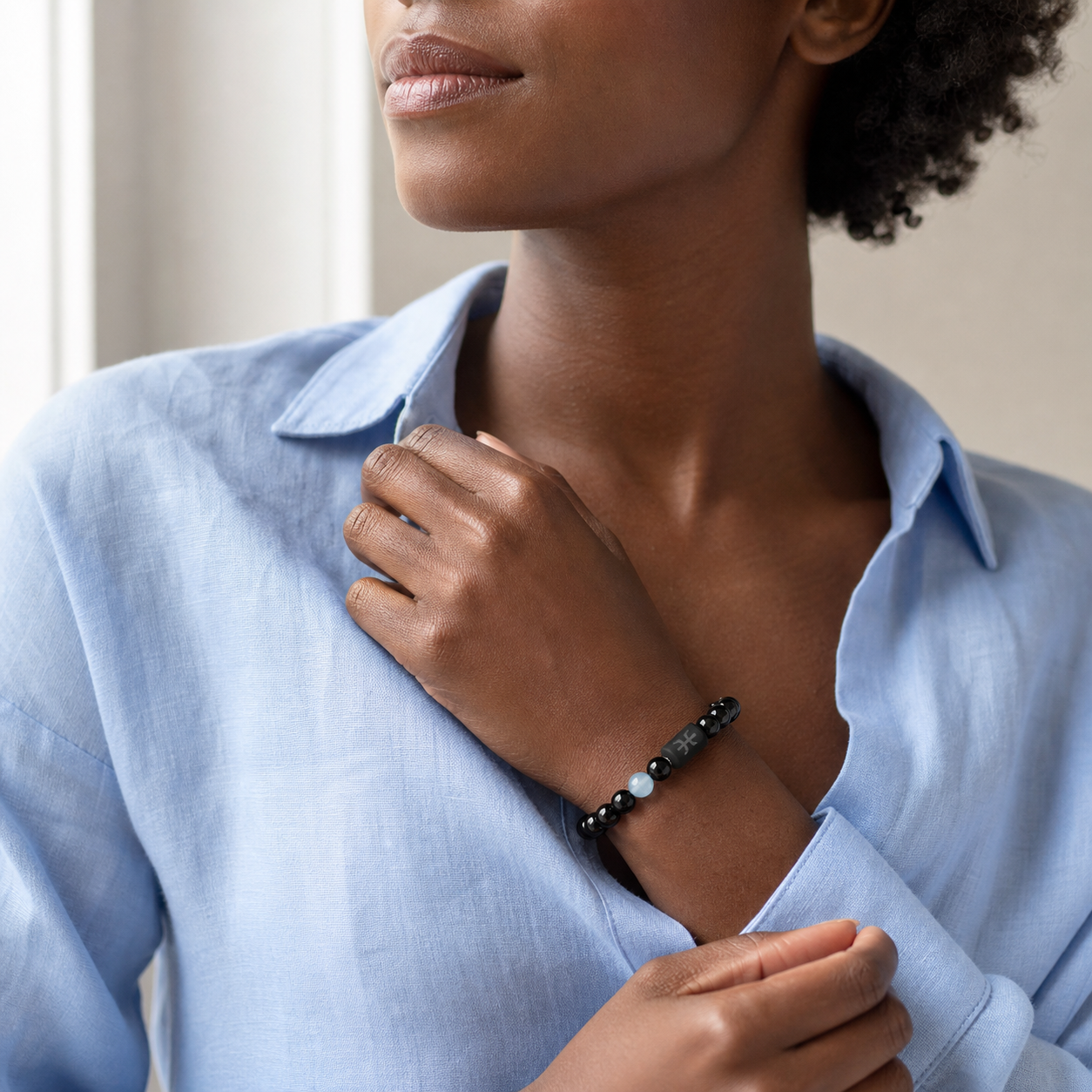 Woman wearing a Pisces Zodiac Bracelet with obsidian and Tiger’s Eye beads