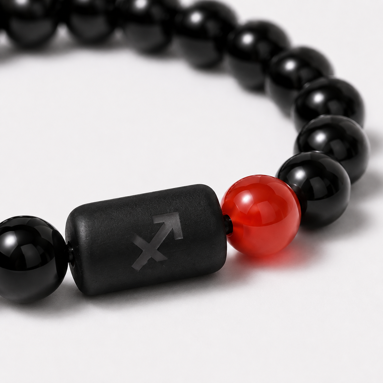 Close-up of the Sagittarius zodiac symbol with obsidian and Tiger’s Eye beads