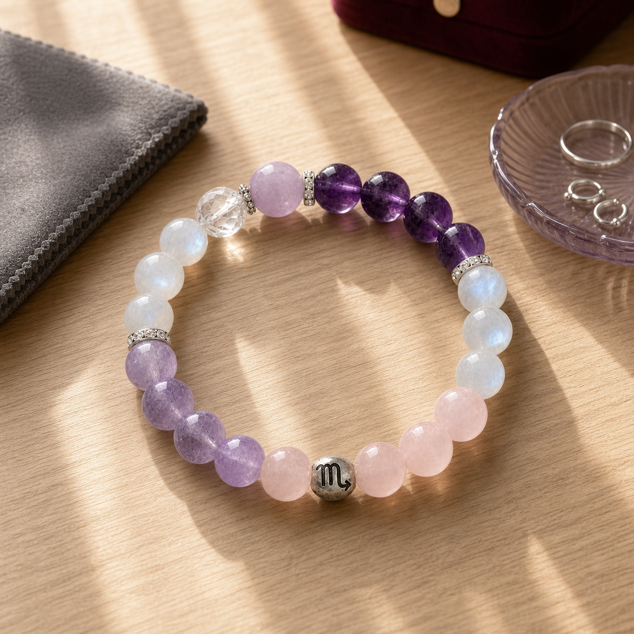 Scorpio bracelet with purple, pink and luminous crystal beads displayed in warm sunlight
