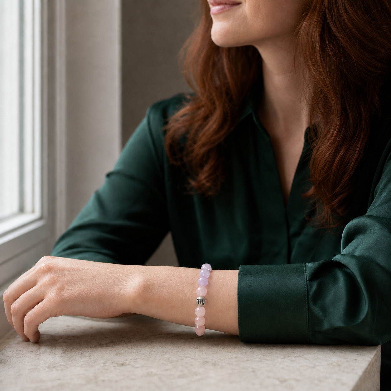 Woman wearing a Scorpio Crystal Bracelet with Amethyst, Kunzite, Moonstone and Rose Quartz beads