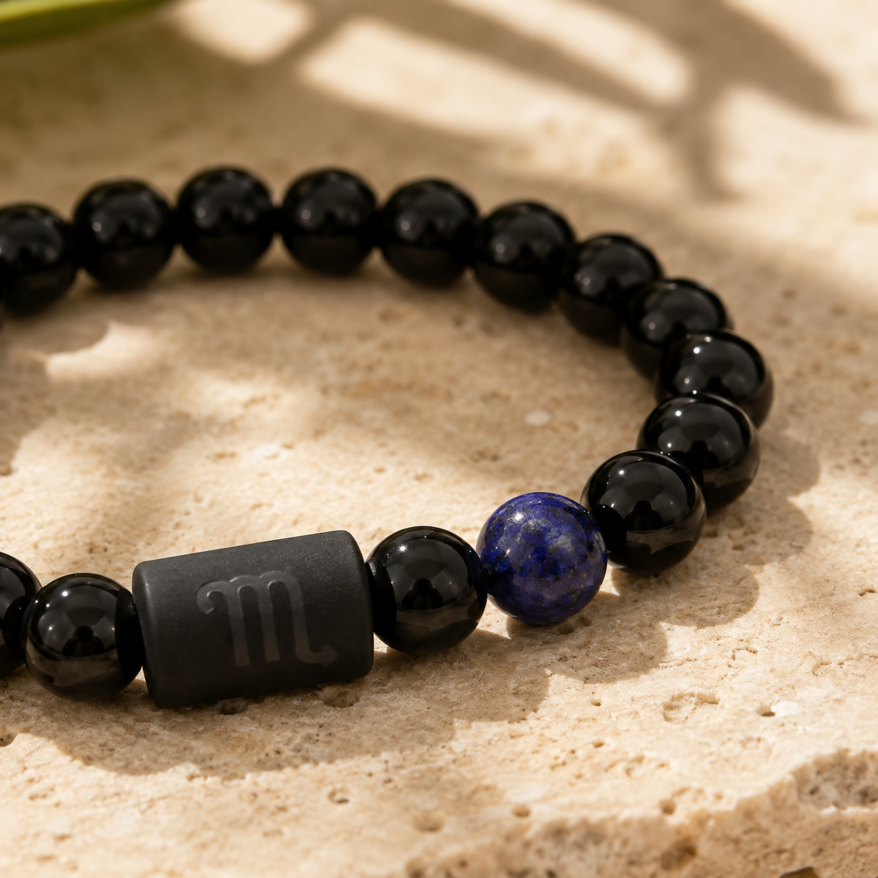 Close-up of the Scorpio zodiac symbol with obsidian and Tiger’s Eye beads